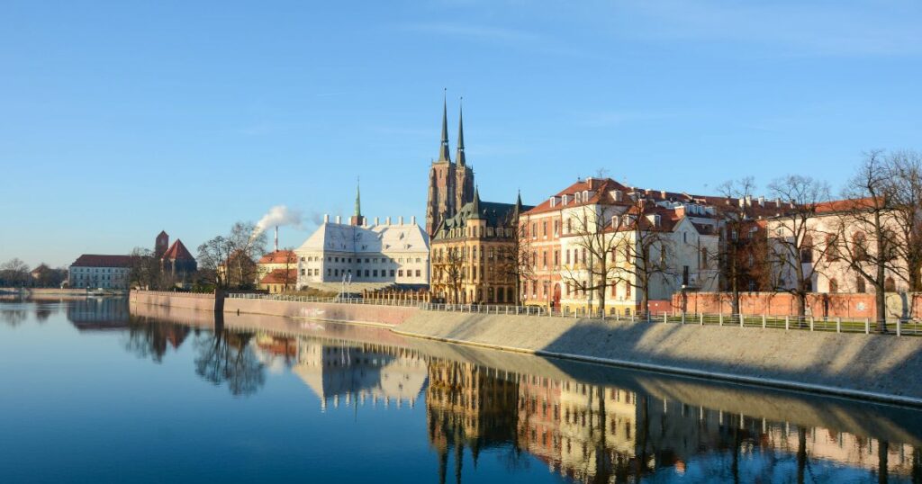 Zimowy widok na Ostrów Tumski we Wrocławiu z odbiciem w Odrze – symboliczne odliczanie do ferii zimowych w województwie wielkopolskim